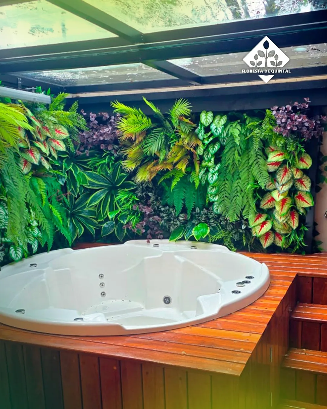 Jardim vertical com folhagens coloridas atrás da hidromassagem